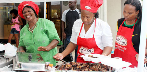 Jamaicans Sila Brown, Ruth Perry and Susan Palmer serve up spicy jerk chicken during last year’s celebration.