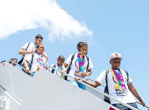 The athletes, festooned with their medals, step off the plane. - PHOTOS: TANEOS RAMSAY