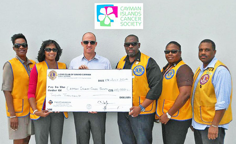 PACCE Chairwoman Carmin Godfrey, second from left, and Lion President Ewan Jacques, fourth from left, present a $20,000 check