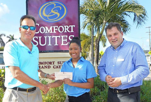 Amy Thompson accepts the scholarship from Gary Rutty, managing director of Comfort Suites, left, and Tom Mason, general manager.