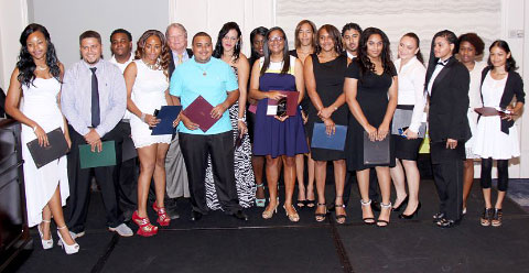 Tourism Minister Moses Kirkconnell, fifth from left, with the first graduating class of the School of Hospitality Studies, at their graduation awards ceremony in July.