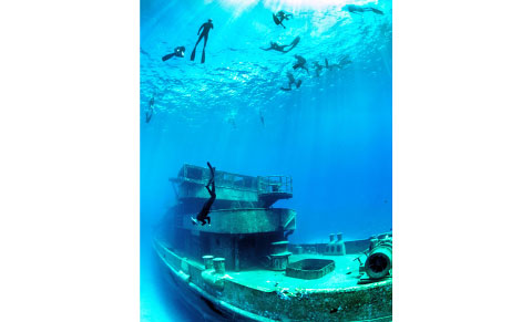 Free divers float above the Kittiwake as one diver heads down to the deck of the ship. - PHOTO: NINA BAXA