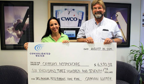Frederick McTaggart, CEO of Consolidated Water, presents Danielle Coleman of Cayman HospiceCare with the check.