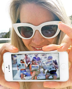 Gemma Critchley shows off a photo sent by her friends in Cayman, showing them reading her husband’s anniversary message to her in the Compass.