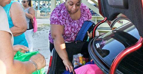 Chelena Simmonds retrieves bags of school supplies for older students as Marilyn Hines double-checks the contents.