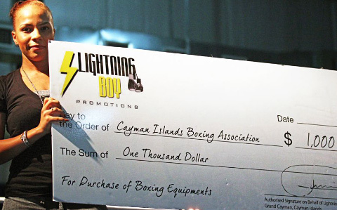 Sheena Scott displays the $1,000 check Lewison donated to the amateur boxers.