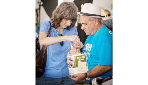 Iris Stoner, whose son Adam had his head shaved, makes a contribution.