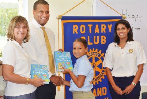 Alyssa Bush receives a dictionary from Education Ministry Councilor Winston Connolly in the company of Sunrise Club President Christine Matthews, left, and Literacy Director Su Mander.