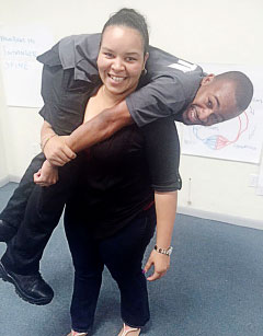 Customs officer Sharissa Ritch demonstrates a ‘fireman’s carry’ with immigration officer Jonathan Myrie. – Photo: RCIPS