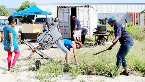 Bonnie Anglin, chairwoman of Youth ACT, center, and other volunteers clear a patch of ground in Rock Hole on Saturday. - PHOTO: JEWEL LEVY