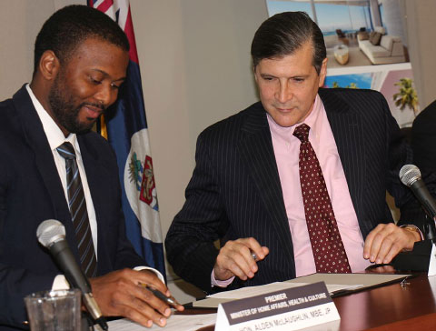 Beach Bay Land Ltd. Managing Director John Layton, right, signs the development agreement with Cabinet Secretary Samuel Rose. - PHOTO: JAMES WHITTAKER