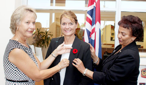 Cathy Frazier, left, and Deborah Ebanks pin Governor Helen Kilpatrick with the first poppy of the 2015 Poppy Appeal. – Photos: Jewel Levy