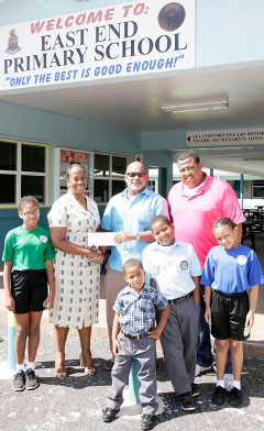 East End Primary School Principal Allison Wallace accepts a check from Donald McLean of Health Care Pharmacy