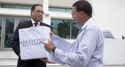 Protest organizer George R. Ebanks, right, presents a petition against high gas prices to Premier Alden McLaughlin.