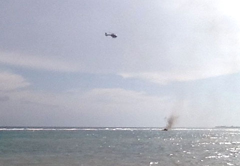 The police helicopter hovers above the boat as it searches the water for anyone who might have been on board. No one was found. - PHOTO: CAROL WINKER