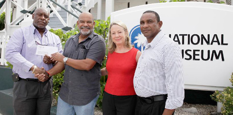 Alfonso Wright, left, receives the donation from Donald McLean, owner of Health Care Pharmacy. Also pictured are Museum Director Peggy Leshikar-Denton and Omar McLean.