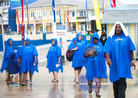 Carnival cruise ship tourists brave the rainy weather in George Town on Wednesday. - PHOTO: TANEOS RAMSAY