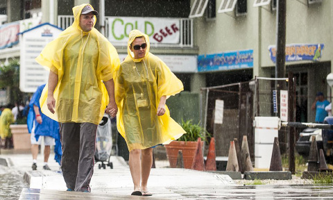 Tourists navigate downtown George Town as a tropical wave soaks Grand Cayman. - PHOTO: Taneos Ramsay
