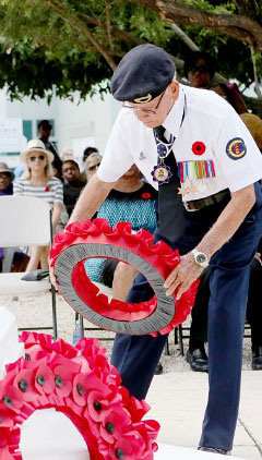 WWII veteran Ewart Ebanks lays a wreath of poppies.