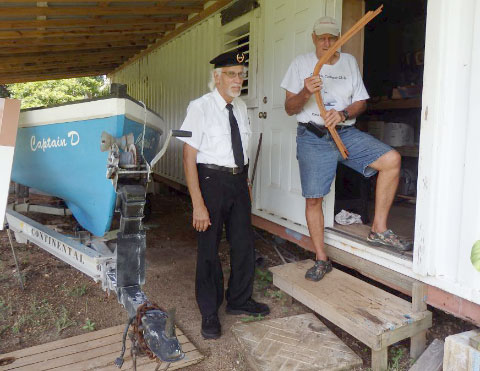 Loxley Banks, a member of the Cayman Islands Veterans Association, with Kem Jackson holding a sample timber at the catboat workshop.  - Photo: Basia McGuire
