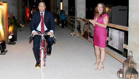 Road to success? Premier Alden McLaughlin, an avid cyclist, tests out the resort’s guest cycles, a signature feature of Kimpton hotels, as Dart Realty chief Jackie Doak looks on.