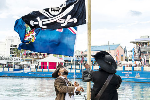 Invading pirates lower the Cayman Islands flag, replacing it with the Jolly Roger. – PHOTO: TANEOS RAMSAY