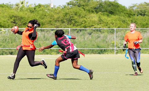 Keisha Solomon avoids a tackle for Team Thunder as Biannca Johnson, right, looks on. - PHOTOS: RON SHILLINGFORD
