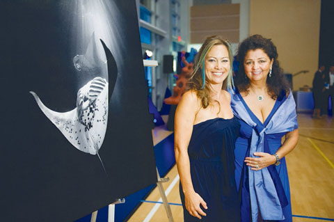 Ellen Cuylaerts, chair of CCMI and contributing artist, and Carrie Manfrino, founder, stand beside one of Cuylaerts