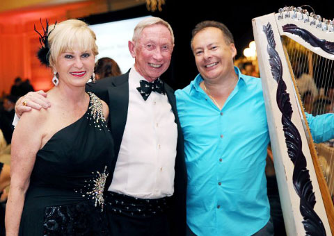 Vicki and David Legge with harpist Eugenio Leon, who provided some of the entertainment for the evening. – Photo: Maggie Jackson