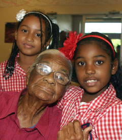 Julia Hydes poses with Sir John A. Cumber students at a seniors celebration in West Bay in 2011. - Photo: Jewel Levy