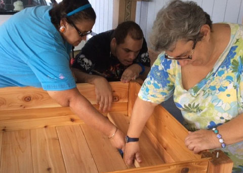 From left, Joy Tibbetts, Jamaree Douglas and Paula Malone build garden beds at the Harmony Learning Centre.