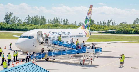 Passengers disembark from a Cayman Airways jet using one of the four new ramps that airline officials say will allow for safer and more comfortable boarding and deplaning.
