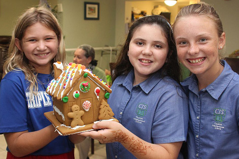 Chloe Gaskill, Emily Walker and Brooke Adair with a gingerbread house.