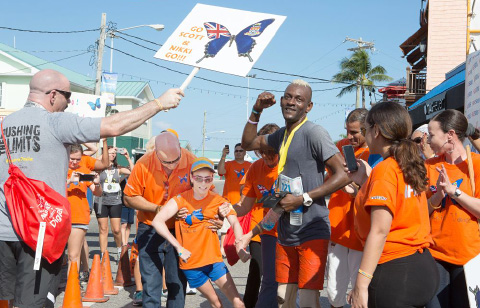 Team Nikki’s Voice celebrates as Nikki Christian crosses the finish line. Ms. Christian, who has cerebral palsy, walked the final 100 or so feet with the help of her family and friends.