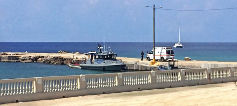 The scene at a dock in Cayman Brac on Aug. 25 after police found a boat with two unidentified bodies on board.