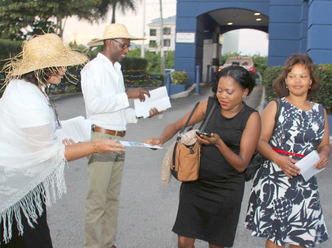 Michele Mogg and Terence Blake hand out programs.