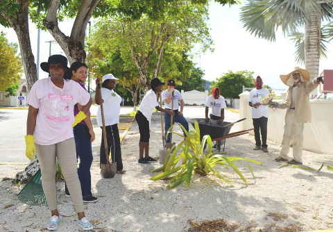 Garden Club horticultural specialist Robert Bennett, right, assists members and Leo Club volunteers with planting flowers at the University College of the Cayman Islands. - Photo: Jewel Levy