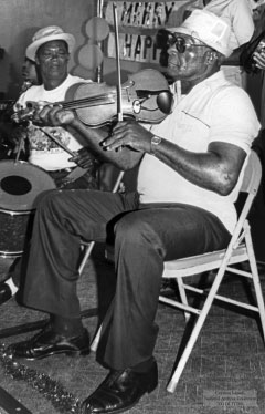 Radley Gourzong plays the fiddle at a kitchen dance.