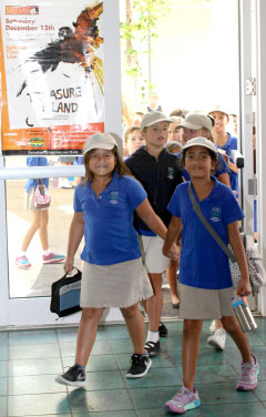 Schoolchildren arrive at the cinema in Camana Bay for Thursday morning