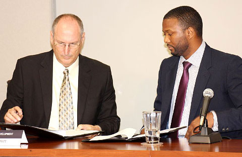Ironwood’s David Moffitt, left, and Cabinet Secretary Sam Rose sign the development agreement at a press briefing on Thursday. – PHOTO: JAMES WHITTAKER