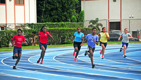 Competitors take the bend at speed in the Year 8 Girls 200m.