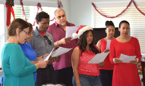 Minister Osbourne Bodden, center, joins in the carol singing.