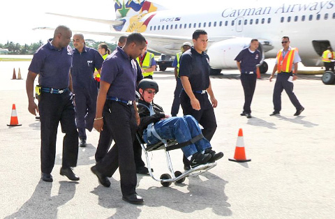 Percival ‘Tommy’ Whorms arrives back in Cayman Monday, escorted by Fire Service colleagues.