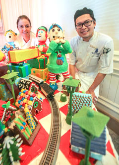 Pastry chefs Melissa Logan and Michael Toa at the gingerbread house.