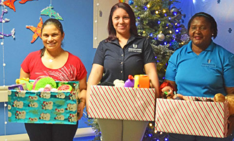 From left, immigration staffers Elizabeth Daniels, Chelsea McField and Chastine Rankine deliver some Christmas gifts.