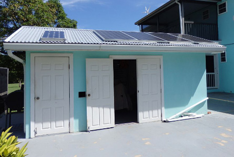 Solar panels, along with the small windmill in background, serve much of the home