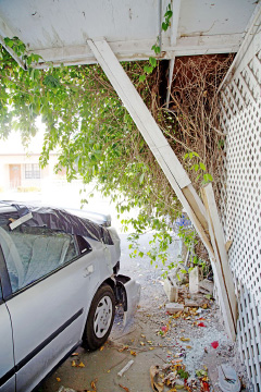 The parked car, which was struck by a passing Chevrolet Equinox, smashed into the house, damaging a fence and a beam.