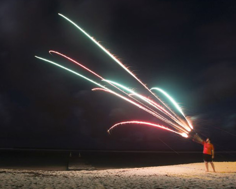 A man shoots a roman candle firework on Spotts Beach over the holiday weekend. - Photo: Kelsey Jukam