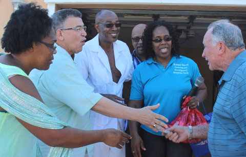 Leader of the Opposition McKeeva Bush, second from left, accepts a donation from Jimmy Powell, right, for the Belford Estates Emergency Response team, joined by response team leaders Millicent and Err