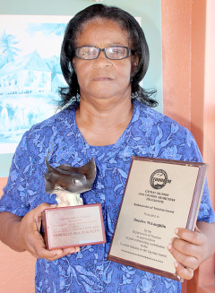 Doralee McLaughlin shows off awards she earned while working in Cayman’s tourism industry. – Photo: Jewel Levy